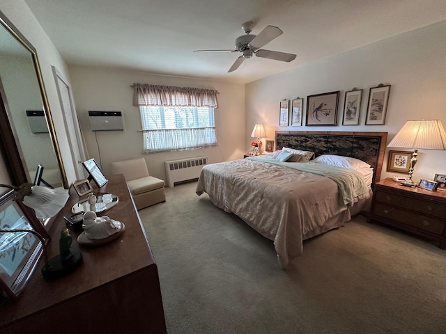 carpeted bedroom with a wall mounted AC, radiator heating unit, and ceiling fan