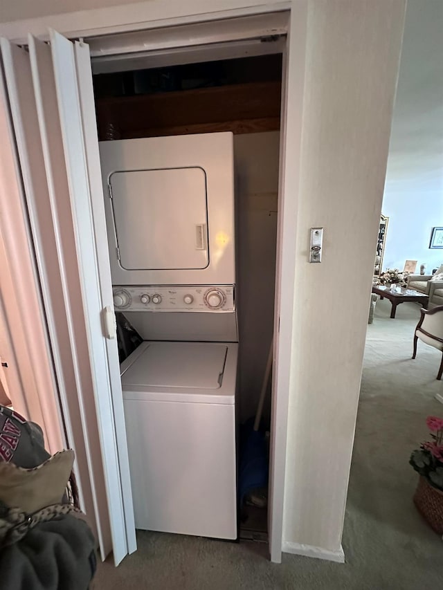 laundry room with carpet and stacked washer / drying machine