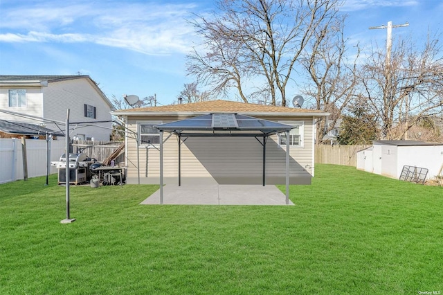 rear view of property with a storage unit, a patio area, and a yard