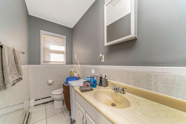 bathroom with vanity, a baseboard heating unit, tile walls, tile patterned flooring, and toilet