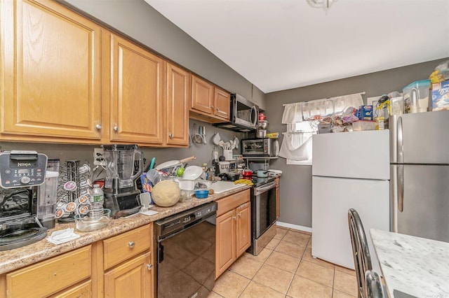 kitchen with appliances with stainless steel finishes, light tile patterned floors, and light stone counters