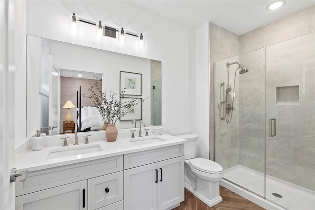 bathroom featuring hardwood / wood-style floors, vanity, toilet, and a shower with door