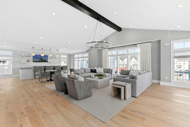 living room with light wood-type flooring, lofted ceiling with beams, and a notable chandelier