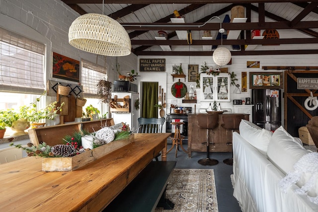 dining room with concrete flooring, lofted ceiling with beams, and a notable chandelier