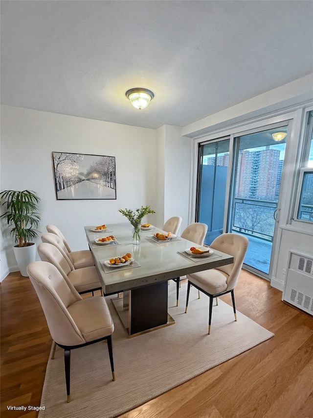 dining area with hardwood / wood-style floors and a healthy amount of sunlight