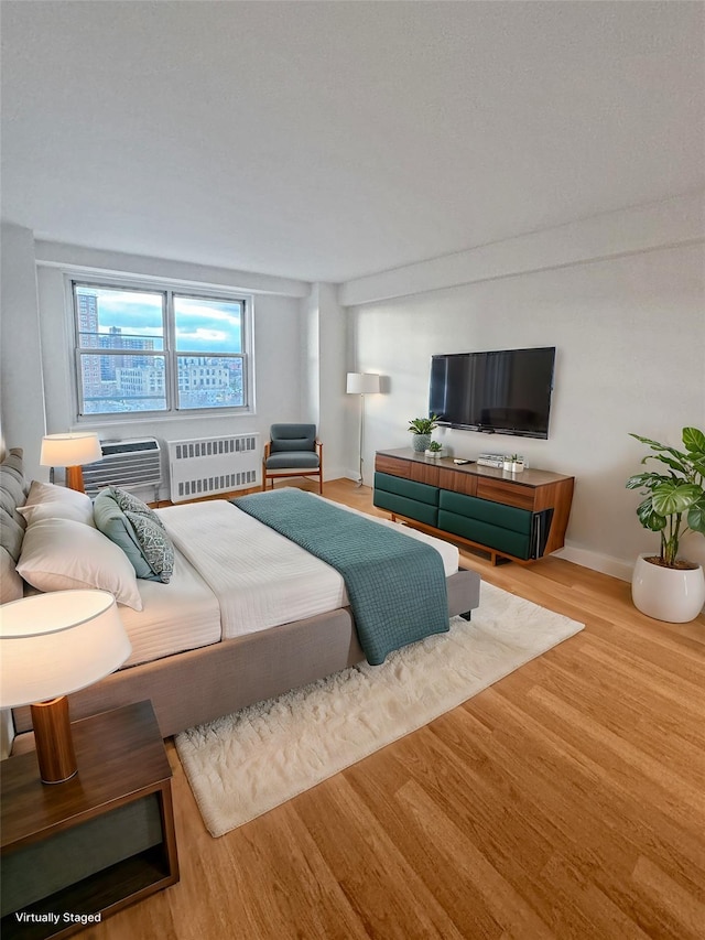 bedroom featuring wood-type flooring and radiator