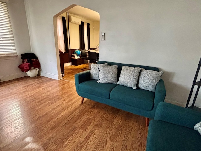 living room featuring hardwood / wood-style floors and a wall unit AC