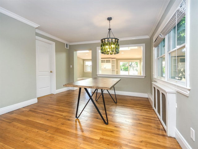 dining room featuring light hardwood / wood-style floors, an inviting chandelier, and ornamental molding