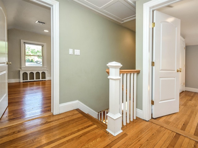 corridor with light wood-type flooring and radiator