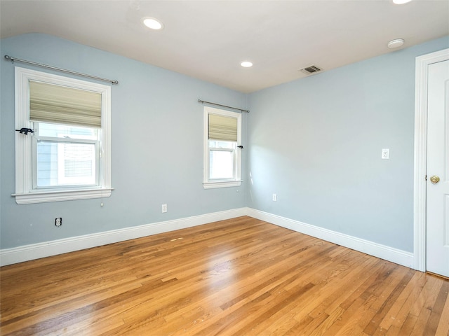 spare room featuring a healthy amount of sunlight and light hardwood / wood-style flooring