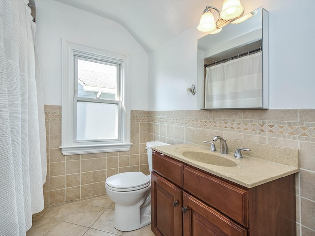 bathroom with tile patterned flooring, vanity, tile walls, and lofted ceiling