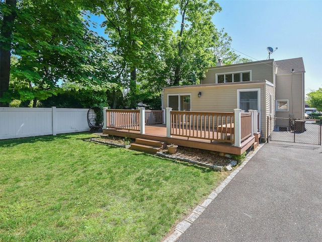 back of property featuring a lawn and a wooden deck