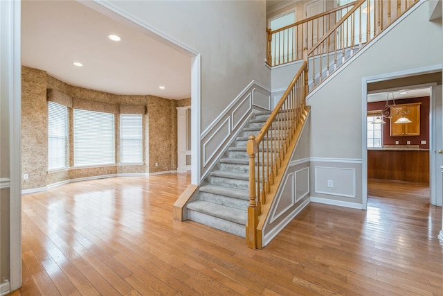 stairway featuring hardwood / wood-style flooring and an inviting chandelier