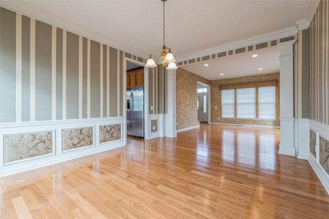 interior space with light hardwood / wood-style floors, crown molding, and a chandelier