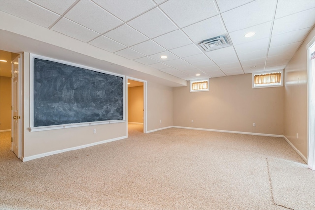 basement featuring carpet flooring and a paneled ceiling