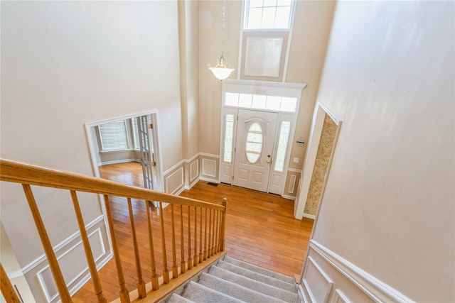 foyer entrance featuring hardwood / wood-style flooring and a high ceiling