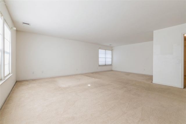 unfurnished room with light colored carpet and a healthy amount of sunlight