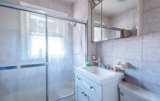 bathroom with plenty of natural light, tile walls, vanity, and walk in shower