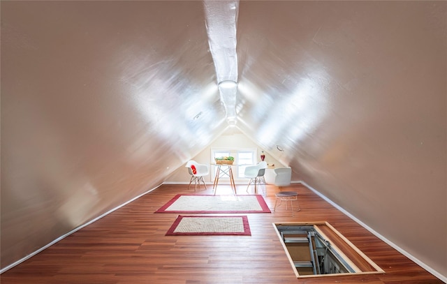 additional living space with lofted ceiling and hardwood / wood-style flooring