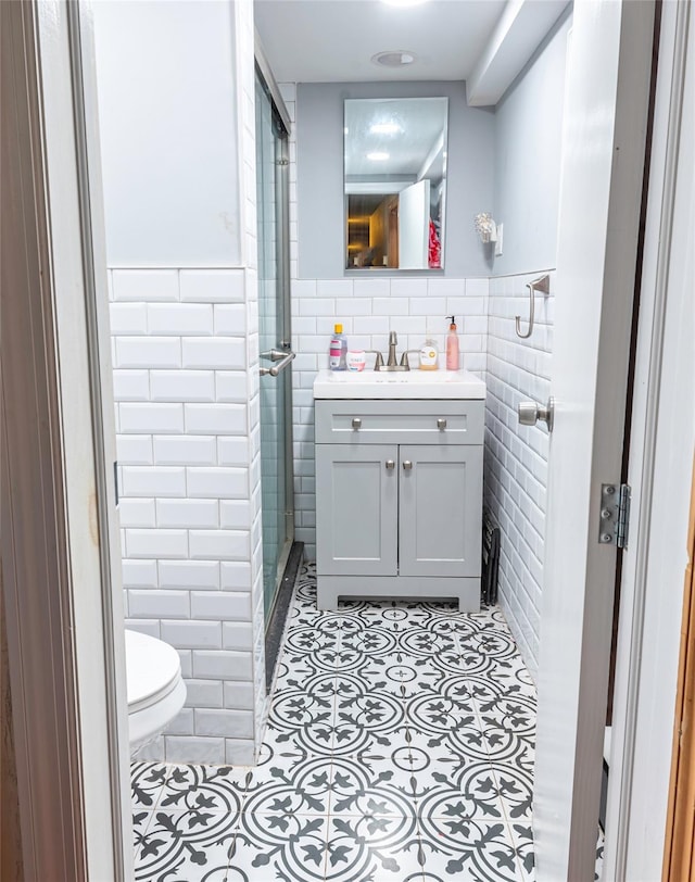 bathroom featuring an enclosed shower, vanity, tile walls, and tile patterned flooring