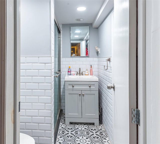 bathroom with tile patterned floors, vanity, and tile walls