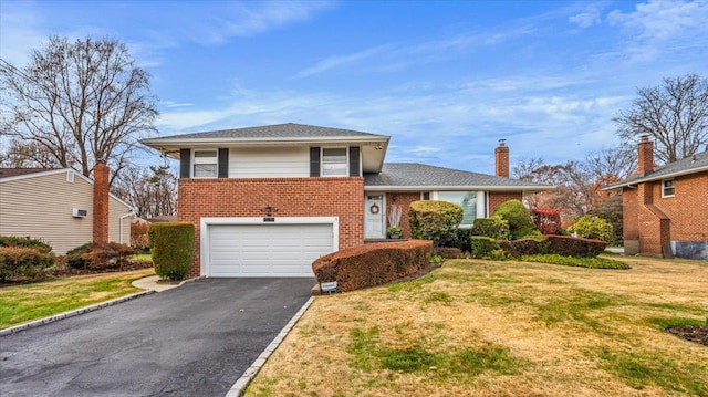 tri-level home featuring a front yard and a garage