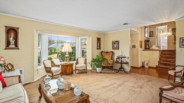 living room featuring hardwood / wood-style floors, ornamental molding, and an inviting chandelier