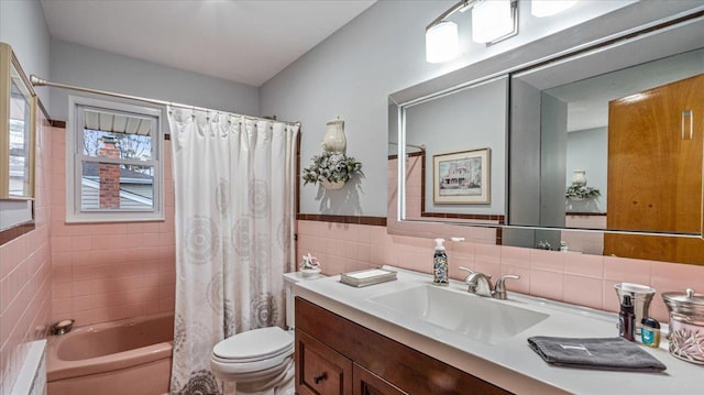 full bathroom with vanity, shower / tub combo, tile walls, and toilet