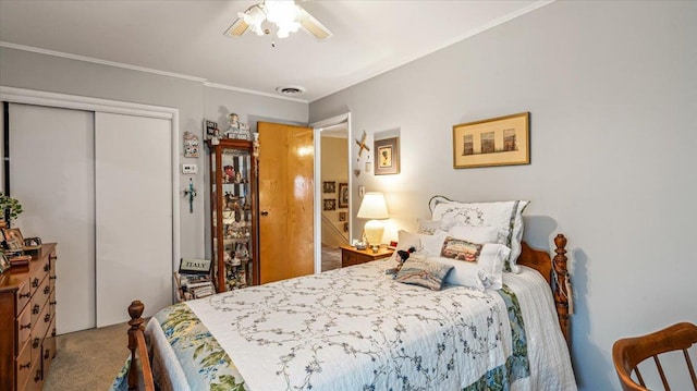 bedroom with ceiling fan, carpet floors, ornamental molding, and a closet