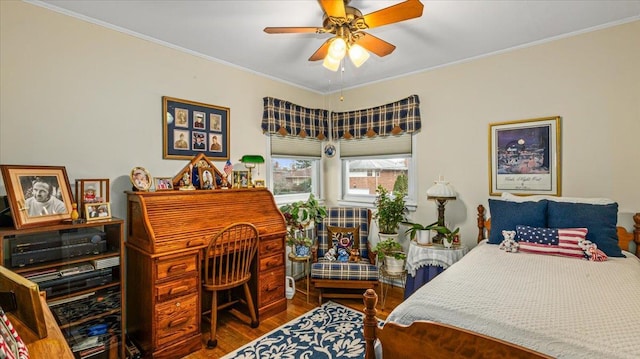 bedroom featuring ceiling fan, crown molding, and wood-type flooring