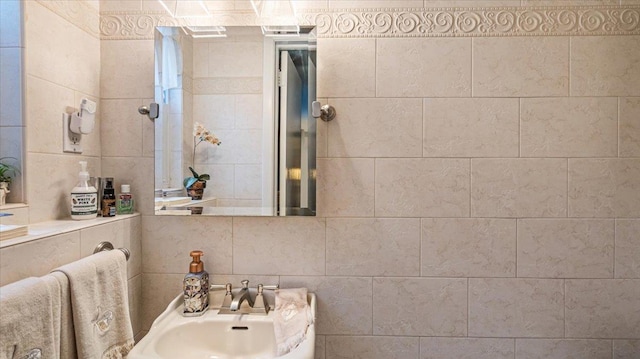 bathroom featuring tile walls and sink