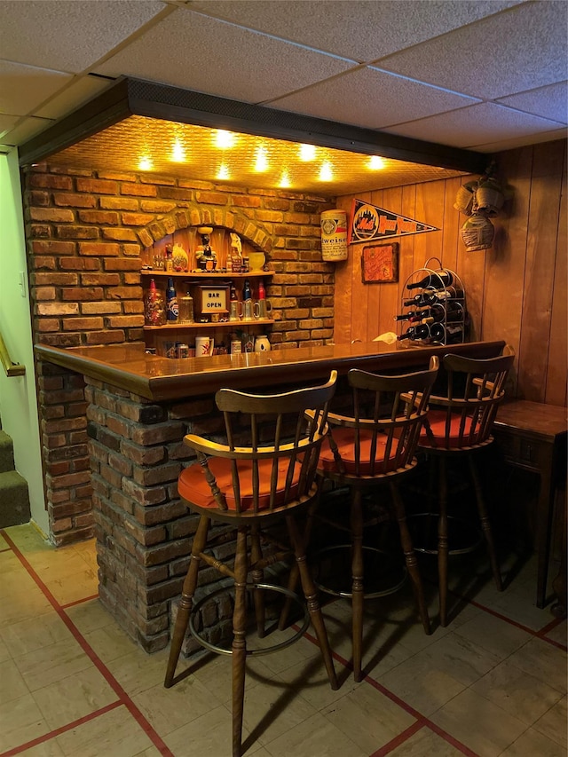 bar with a paneled ceiling and wooden walls