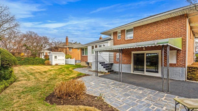 rear view of property featuring a lawn, a storage unit, and a patio