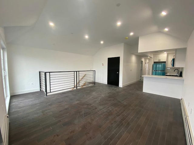 unfurnished living room featuring vaulted ceiling, dark hardwood / wood-style flooring, sink, and a baseboard heating unit