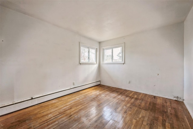 empty room with baseboard heating and hardwood / wood-style flooring