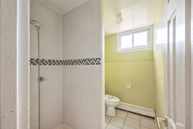 bathroom with tiled shower, tile patterned floors, toilet, and a baseboard heating unit