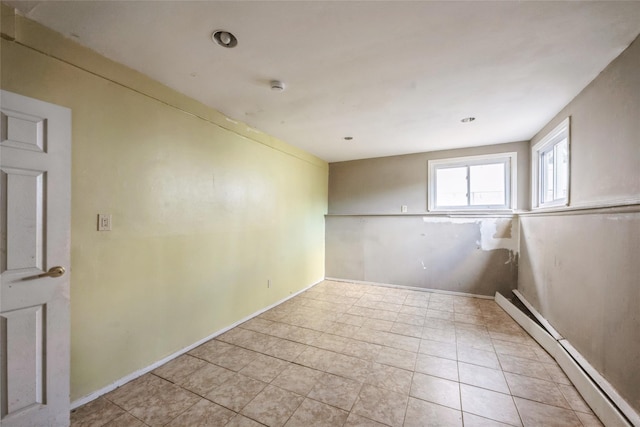 tiled spare room with a baseboard radiator