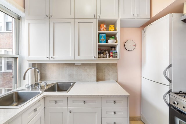 kitchen featuring white cabinets, electric range oven, backsplash, and white refrigerator