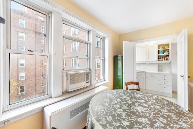 bedroom featuring cooling unit, radiator, and multiple windows