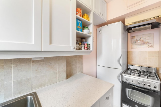 kitchen featuring white cabinets, gas range, and decorative backsplash