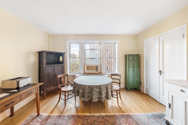 dining area with cooling unit and light hardwood / wood-style floors