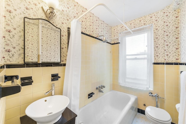 full bathroom featuring shower / bath combo, toilet, sink, and tile walls