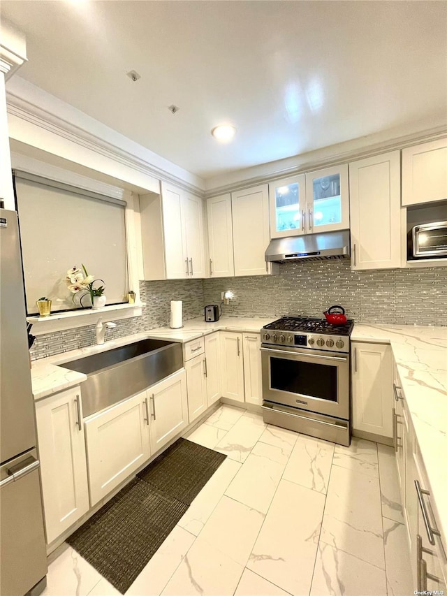 kitchen featuring backsplash, light stone counters, stainless steel appliances, sink, and white cabinets