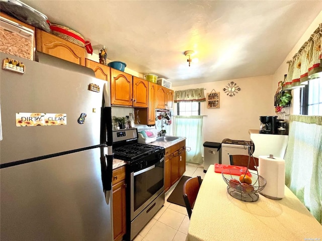 kitchen featuring sink, light tile patterned flooring, and appliances with stainless steel finishes