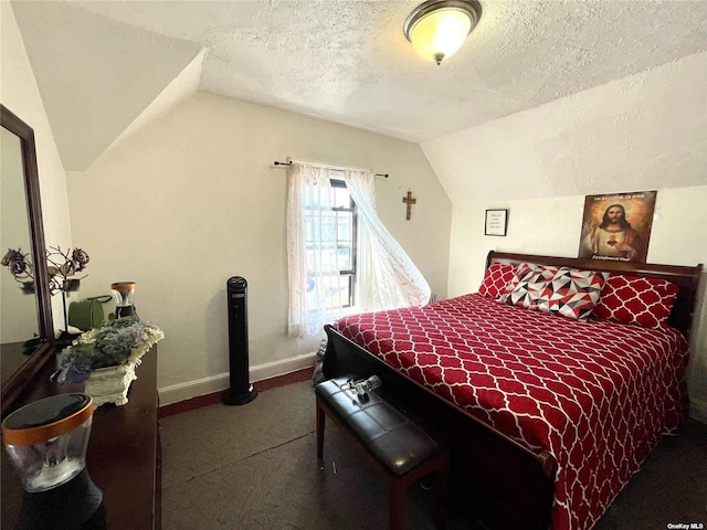 bedroom featuring lofted ceiling and a textured ceiling