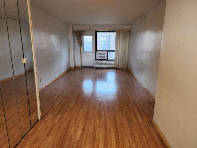 spare room featuring light wood-type flooring and baseboard heating