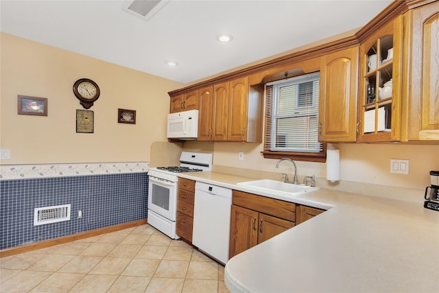 kitchen with light tile patterned flooring, white appliances, and sink