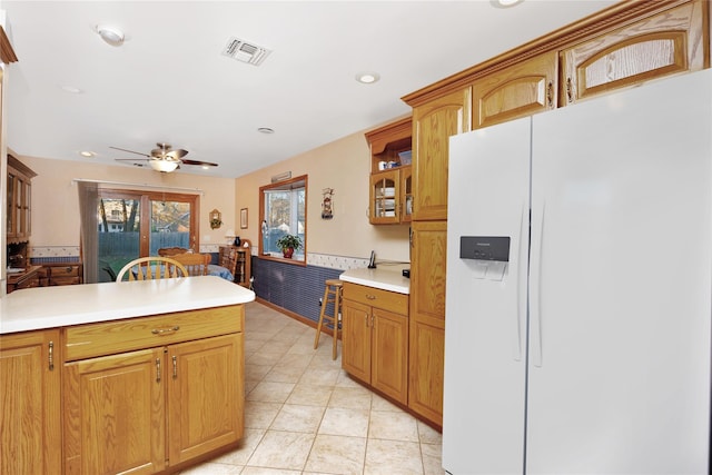 kitchen featuring ceiling fan, white fridge with ice dispenser, and light tile patterned floors