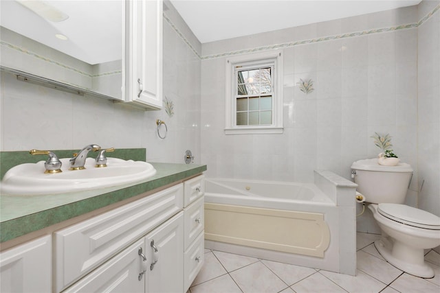 bathroom featuring vanity, a tub to relax in, tile patterned floors, and tile walls