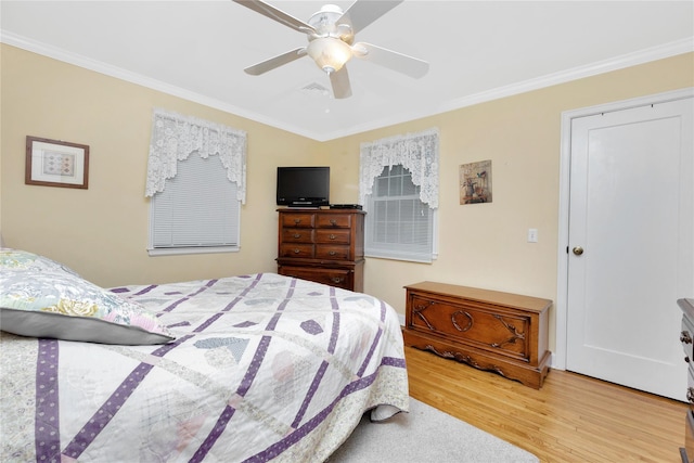 bedroom with light hardwood / wood-style floors, ceiling fan, and ornamental molding